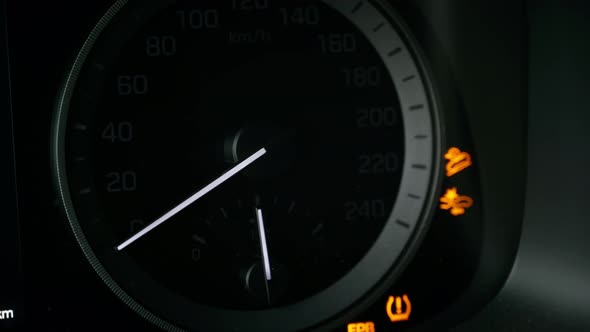Close-up of a tachometer and fuel gauge in a car. The instrument panel lights up.