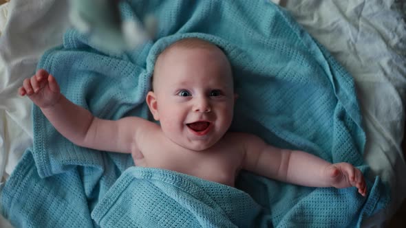 Adorable Little Toddler Boy Smiling at Camera Boy Laughing and Happy in Bed Toy Overhead alt