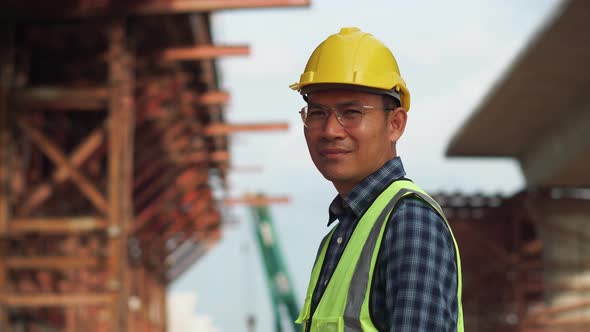 Asian construction engineer checking project at the building site, Foreman worker in hardhat at the