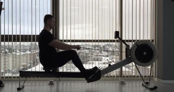 A Man Goes In For Sports In The Gym. Rowing  alt