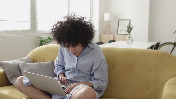 Young Adult Woman Using Laptop Computer Relaxing at Home alt