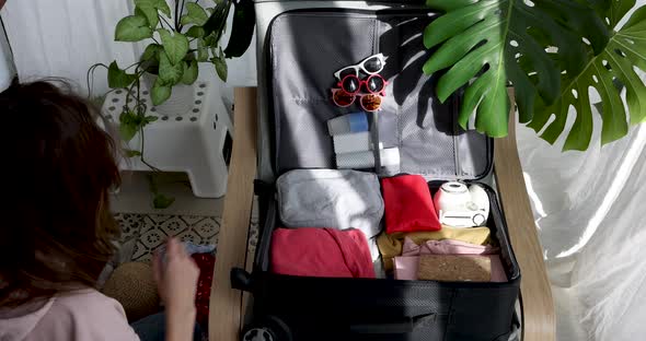 Woman is Going to Rest Trip and Summer Things Put Together in Suitcase