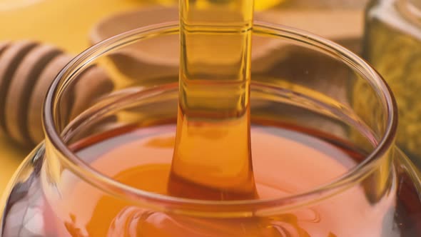 Honey Pouring Into Glass Bowl with Honeycomb and Propolis Liquid Sugar Syrup