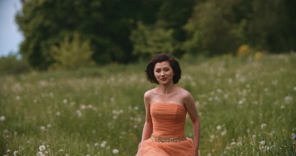 Portrait of Pretty Asian Woman Bride Running in Slow Motion on Summer Field alt