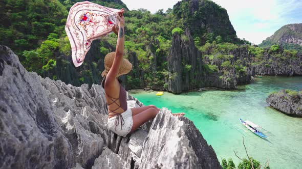 Woman Holding Shawl In Breeze On Limestone Rocks alt