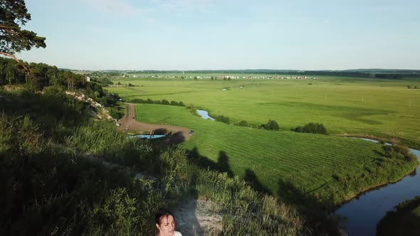 Aerial Top View of Young Happy Woman Sitting in Lotus Pose and Putting Up Hands in Namaste Mudra