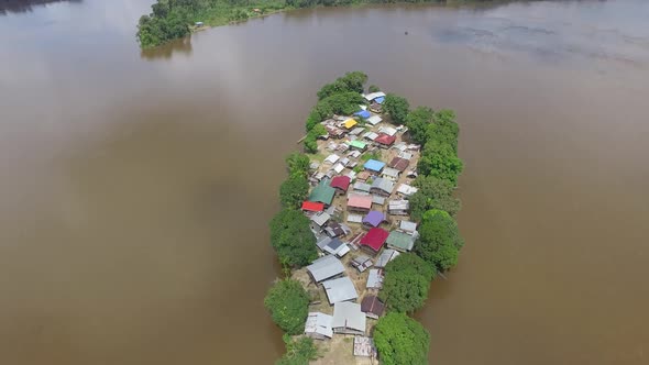 Aerial drone footage flying over unique remote island village in the Amazon South America. alt