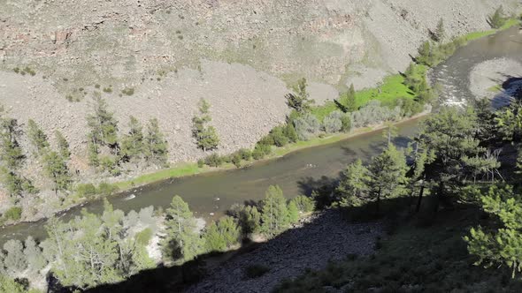 Broken Crumbled Rocks Spilling From the Narrow Canyon Slope Ridge Towards the Deep Valley Floor alt