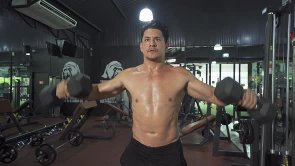 Portrait of strong caucasian man lifting dumbbells, doing exercise, working out, and training alt