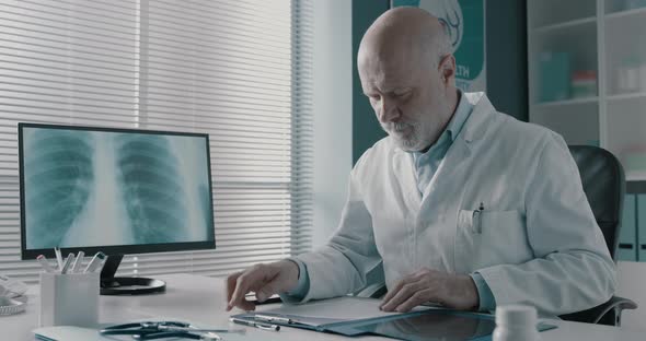 Professional doctor checking medical records in his office