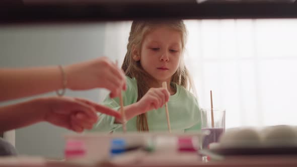 Concentrated Little Girl with Mother Draws Marbling Patterns alt