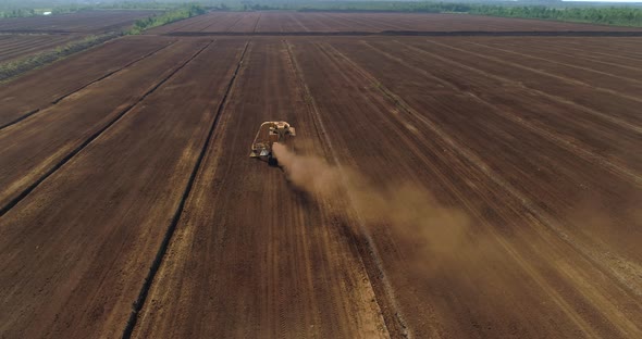 Peat Harvesting Machinery Extracting Peat Dust in Drained Bog Aerial View alt