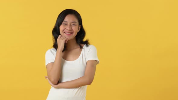 Portrait of pretty Asian woman in white plain t-shirt posing and smiling