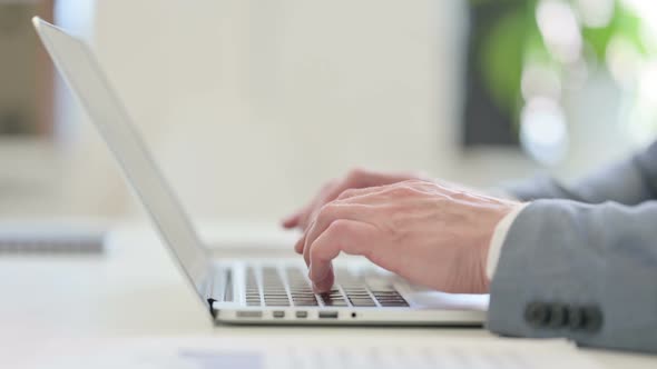 Close Up of Businessman Typing on Laptop alt