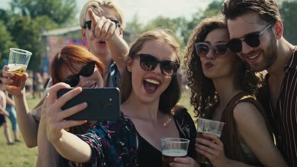 Group of caucasian friends making funny faces for a common selfie on music festival. Shot with RED h alt