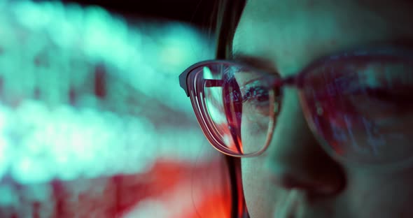 Closeup of Young Adult Female Wearing Reflective Glasses Analyzing Cyber Security Code Data Working alt