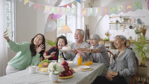 Group of Asian senior people celebrating birthday at retirement home with friends alt
