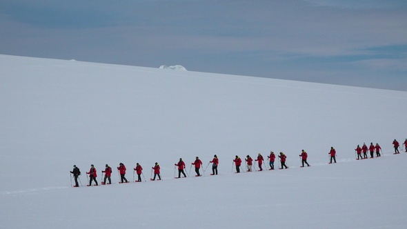 Antarctica Peninsula.  People hikers climbing mountain, team work, travelling, trekking. alt