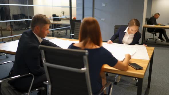 Confident Businesspeople Giving Drawing Presentation on Drawings to Colleagues alt