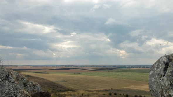 Clouds Moving Over Rock Formation and Field