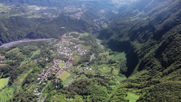 Drone footage of a village between cliffs and the mountains of Salazie on the Reunion island. alt