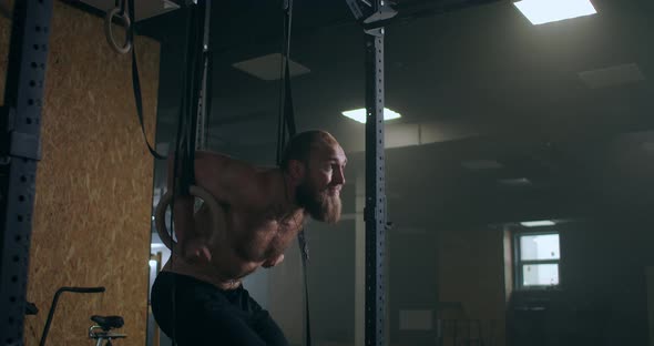 Fitness, Bodybuilding and People Concept Young Man Doing Push-ups on Gymnastic Rings in Gym alt