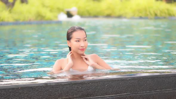 Young asian woman enjoy around outdoor swimming pool for leisure