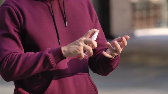 Portrait of Young Man That Sanitizes Alcohol Antiseptic Hands To Protect From the nCov-19 alt