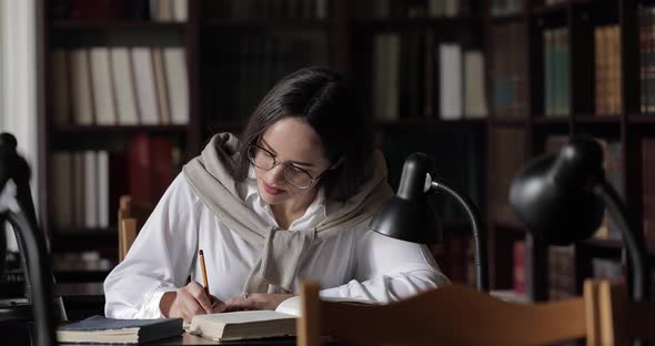 Student Writing Notes in Library