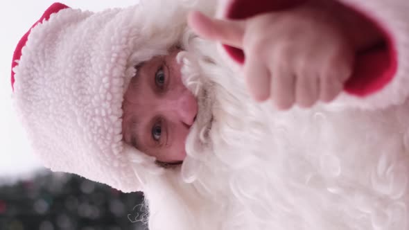Vertical Video Santa Claus Showing Thumb Up Class Gesture Sign Looking at Camera alt