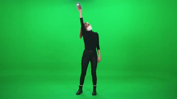 Female Dancing at a Music Concert Woman in Protective Medical Mask at a Concert Holding Smartphone alt