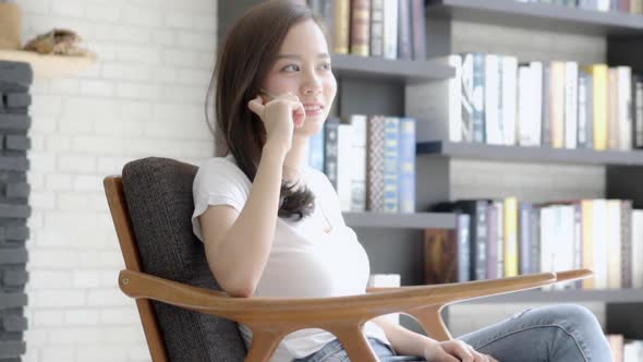 Young asian woman using smart phone talking enjoy. alt