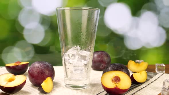 Plum Juice Poured Into Glass with Ice Cubes