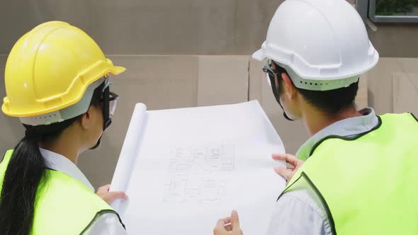 Asian colleague workers people wearing protective safety helmet and glasses onsite of architecture. alt