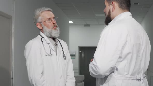 Senior Doctor Shaking Hands with His Colleague at the Hospital