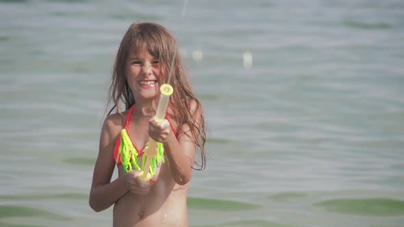 Child Playing with Water Gun alt