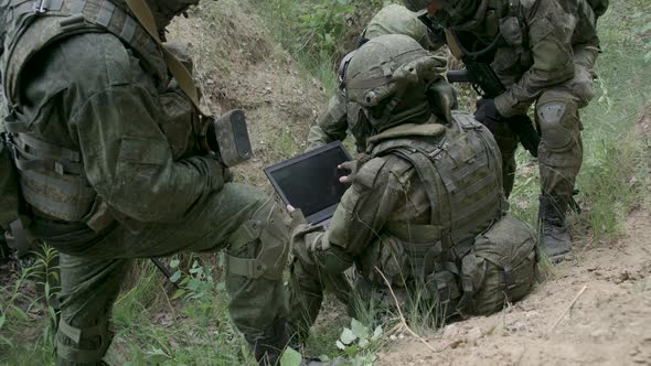 Soldiers in Camouflage in Ambush Military Engineer Uses a Laptop Navigation System Military Action alt