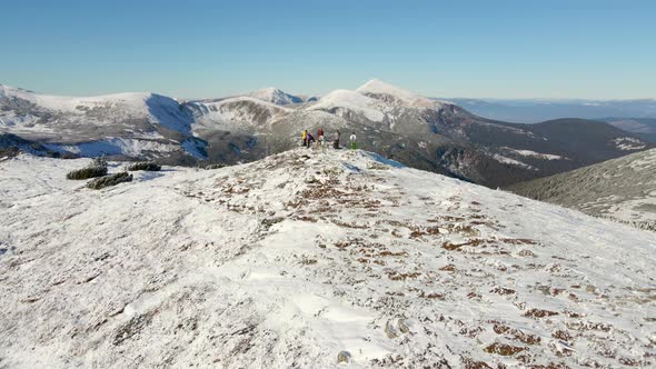 Travelers Stand on Top of a Snowy Mountain
