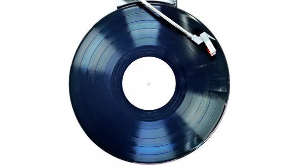 An old record spinning on a turntable isolated on white