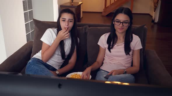 Teenage Girls Watching TV and Eating Popcorn
