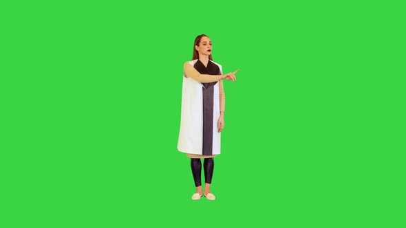 Cyber Girl Stands Operating Virtual Monitors on a Green Screen Chroma Key