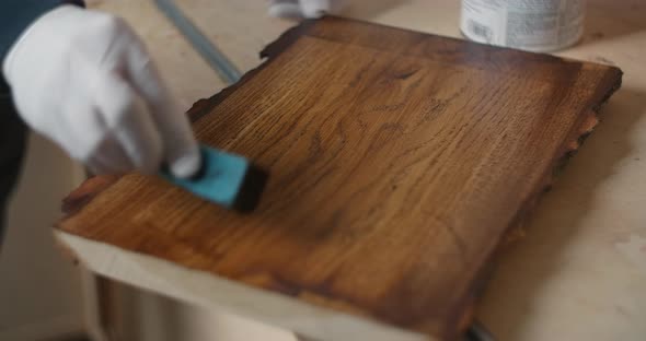 Craftsman Treats the Board with Wood Impregnation Coating a Wooden Surface with Oil Wood Tinting alt