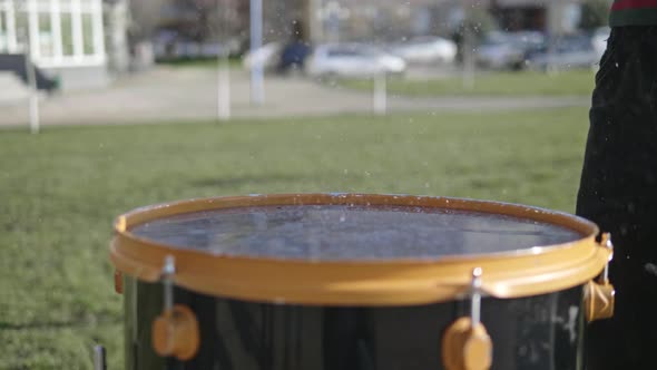 Drumsticks in Male Hands Beat the Big Drum on the Street