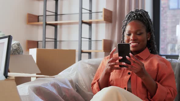 Happy Woman with Smartphone Moving to New Home