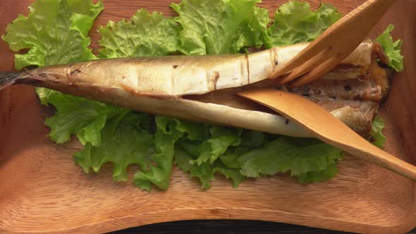 Closeup of a Knife and Fork Cutting a Tasty Grilled White Mackerel Fish alt