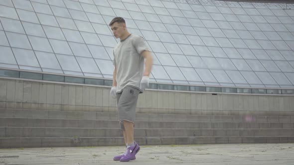 Sport Performance of Young Strong Caucasian Sportsman Outdoors. Wide Shot Portrait of Brunette alt