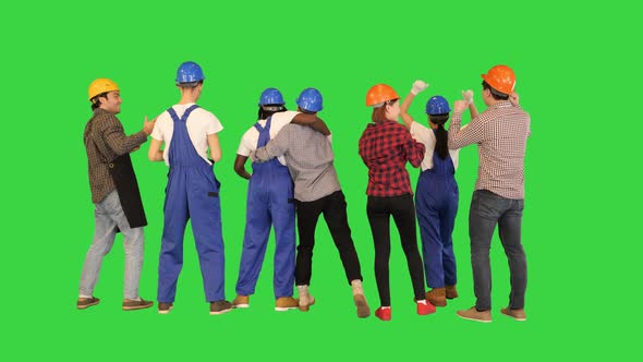 Group of Construction Workers Celebrating Victory with Arms Raised Up on a Green Screen Chroma Key alt
