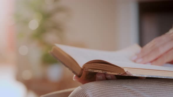 Woman Reads Book at Home. Hand Turning Pages of a Book