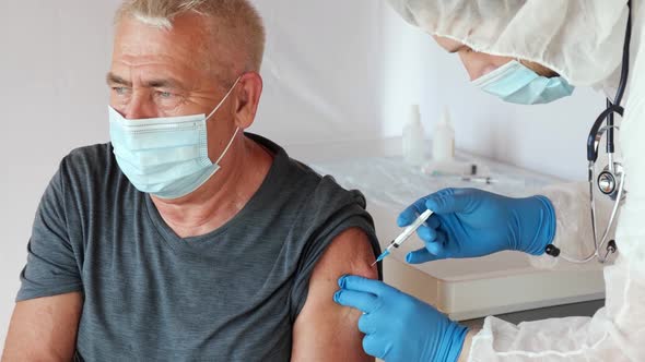 Doctor Vaccinating Senior Man. Doctor Giving COVID19 Coronavirus Vaccine Injection to Elderly Man. alt