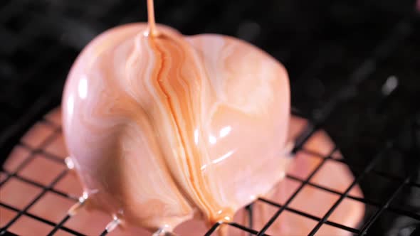 Closeup of a Pouring Glazing Over Heart Shape Dessert in Slow Motion